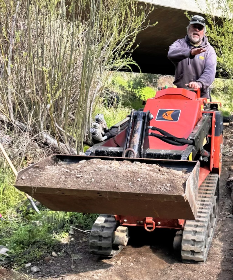 Joe bringing in material to fill in the gaps and smooth the path.